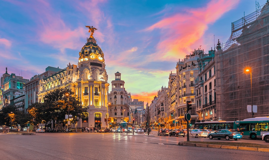 View of Gran Vía in Madrid with the iconic Metropolis Building at sunset.