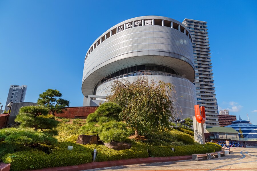 Osaka Science Museum with modern architecture and lush surroundings in Osaka, Japan.