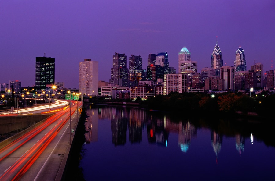 Night view of the Schuylkill River Trail with skyline and river reflections in Philadelphia.