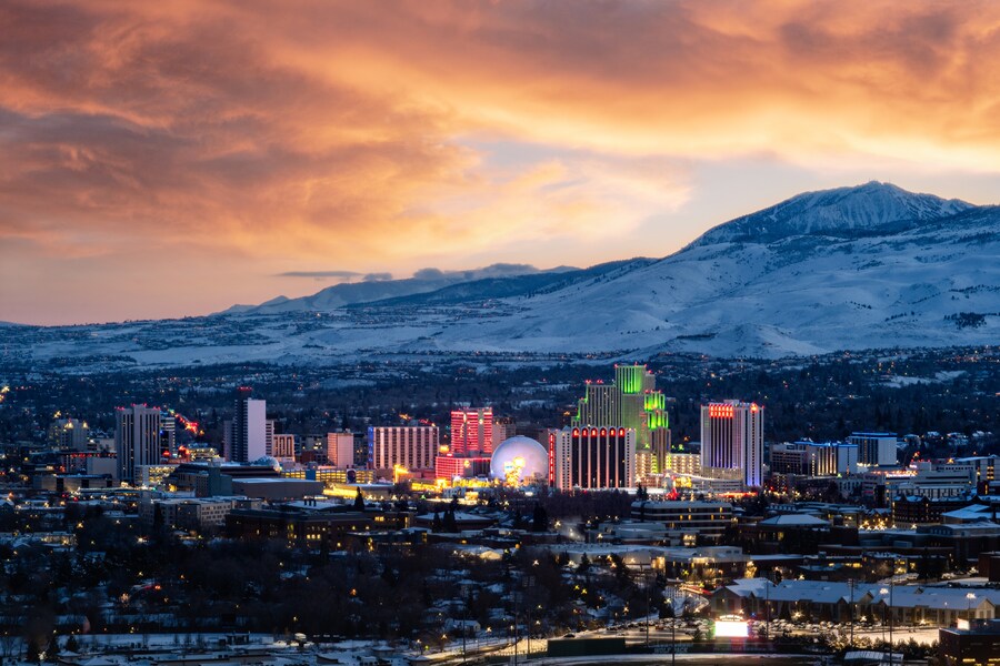 Night view of the Peppermill Resort Spa Casino in Reno, Nevada, featuring vibrant lighting and Tuscan-inspired decor.