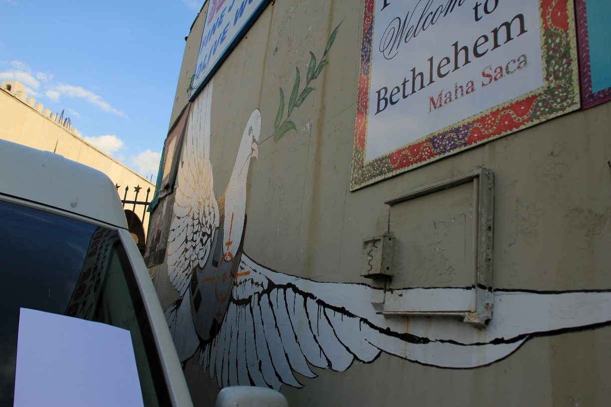 The iconic Armored Dove of Peace, by famed graffiti artist, Banksy. 

Unfortunately, Maha Saca, the founder of the Palestinian Heritage Center, is currently at a war of her own with the renter of the next shop who insists on parking his van in front of the Peace Dove. So my picture of it is not great. She, the sassy lady she is, had us write a letter of our disappointment to the shop owner and leave it on his car.

Banksy stayed with Mrs. Saca for 3 days while in Palestine, and the Peace Dove was his last installation before leaving. He went over several ideas with Mrs. Saca before finally agreeing on the piece she approved of. 

Despite gov influenced fears, Palestine turned out to be a fascinating country full of wonderful welcoming people. I highly recommend anyone in the area to go. If you do make your way over, here is the name and contact info for our taxi driver who I know would love to show you around: Loui Skoda, email: loui_skoda2009@yahoo.com, cell: 00972598303603 

