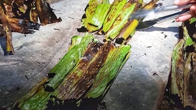 This native delicacy is very popular in Ilocos Region, Philippines. Its a kind of Snack or can be a dessert made of glutinous rice, coconut milk, molasses, grated young coconut with sesame seads and wrapped in banana leaves. Its cooked in a traditional way, and its usually prepared during Christmas time and New Years Eve. Picture was taken during the Farmers Festival native delicacy cooking contest  but this can be bought at the Batac Market. #LikeALocal #nativedelicacy #Mochi/Tupig