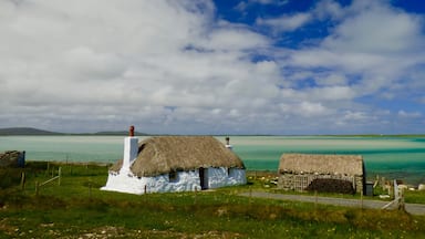 The restored Cottages of Struan near Malacleit are a beautiful example of traditional life on the Isle of North Uist, the clear waters of the bay shown the underlying white sands and the Isle of Vallay in the distance. 