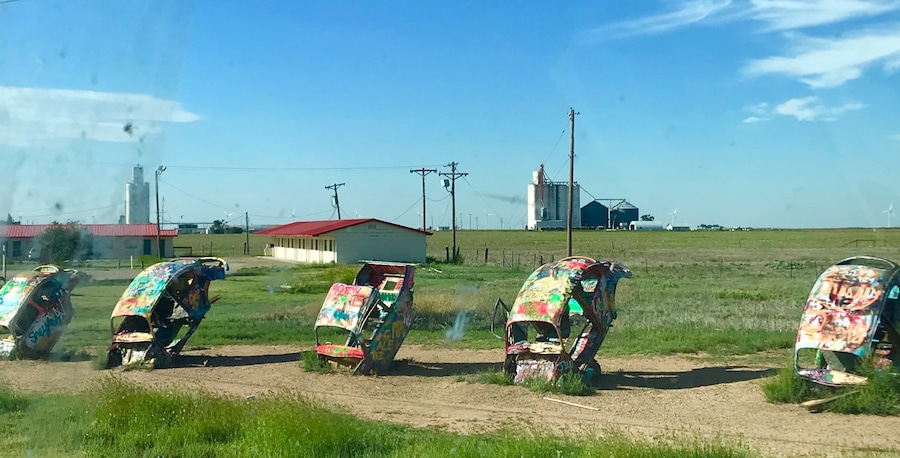 lug Bug Ranch -- also known as Bug Ranch, Bug Farm, and Buggy Farm -- was created in 2002. The five wrecked Volkswagen Beetles, buried hood-down in the ground, were the idea of the Crutchfield family, who owned the Longhorn Trading Post and Rattlesnake Ranch next door.
Slug Bug Ranch.
It began when a huge corporate Travel Plaza was built on the opposite side of the Crutchfields interstate exit. They figured they could stay in business if they could siphon away traffic with something eye-catching and engaging. Slug Bug Ranch seemed a natural choice: a parody of the popular Cadillac Ranch, 35 miles west. At the time, the Beetle wrecks were painted a pristine bright yellow, and a sign next to them encouraged, "Sign a Bug."
Slug Bug Ranch.
The Crutchfield's were right about one thing: Slug Bug Ranch has proved popular as an attraction. Unfortunately, it flopped as a business plan, and the Trading Post closed only a year after it was built. Its advanced state of decay is a testament to the vigorous love it has endured from Route 66 travelers, who have felt free to modify the abandoned artwork with spray paint and whatever crowbars, hammers, blowtorches, etc. they apparently carry in their vehicles.