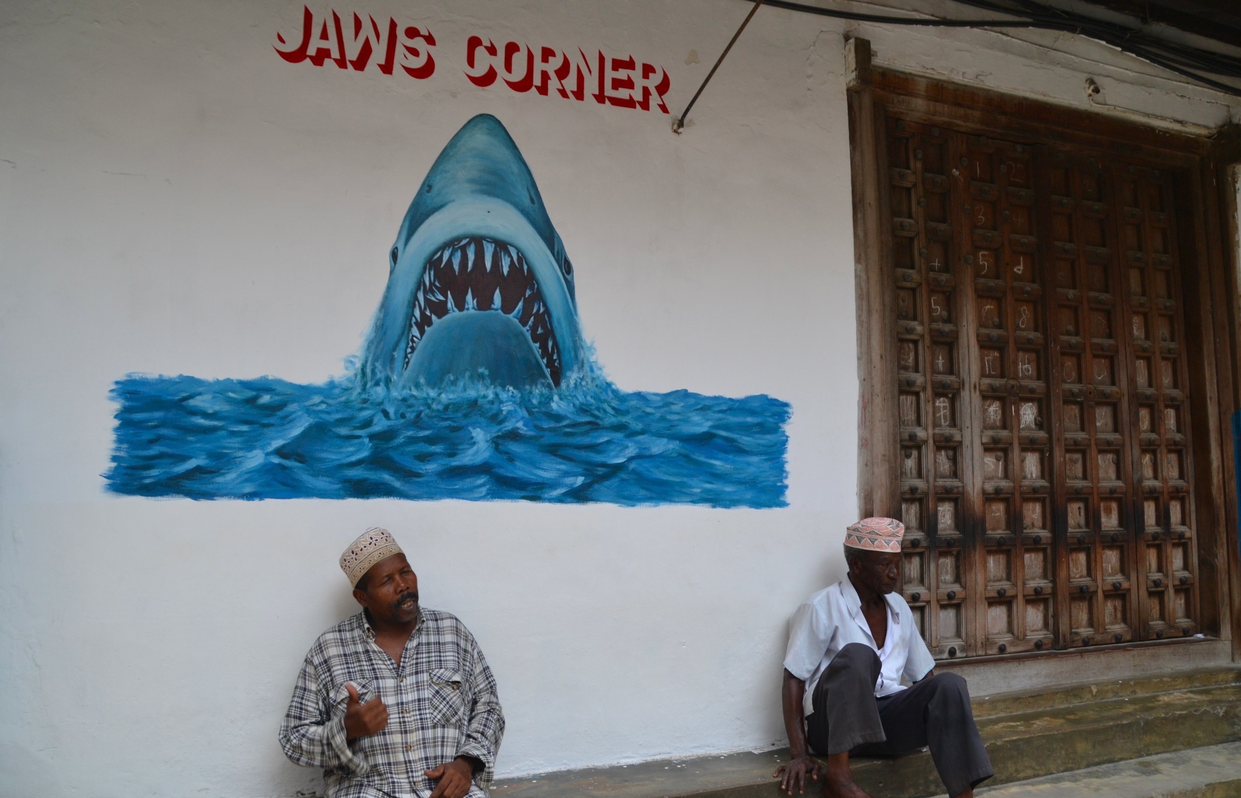 Jaws corner is a place where the locals gather to discuss politics and other things or just drink a cup of coffee. This corner is located somewhere in the maze like streets of Stone Town, on Zanzibar. It is a pleasure getting lost in all the tiny alleys while talking to some locals and looking at all the amazing doors and buildings.

#zanzibar #tanzania #streetart
