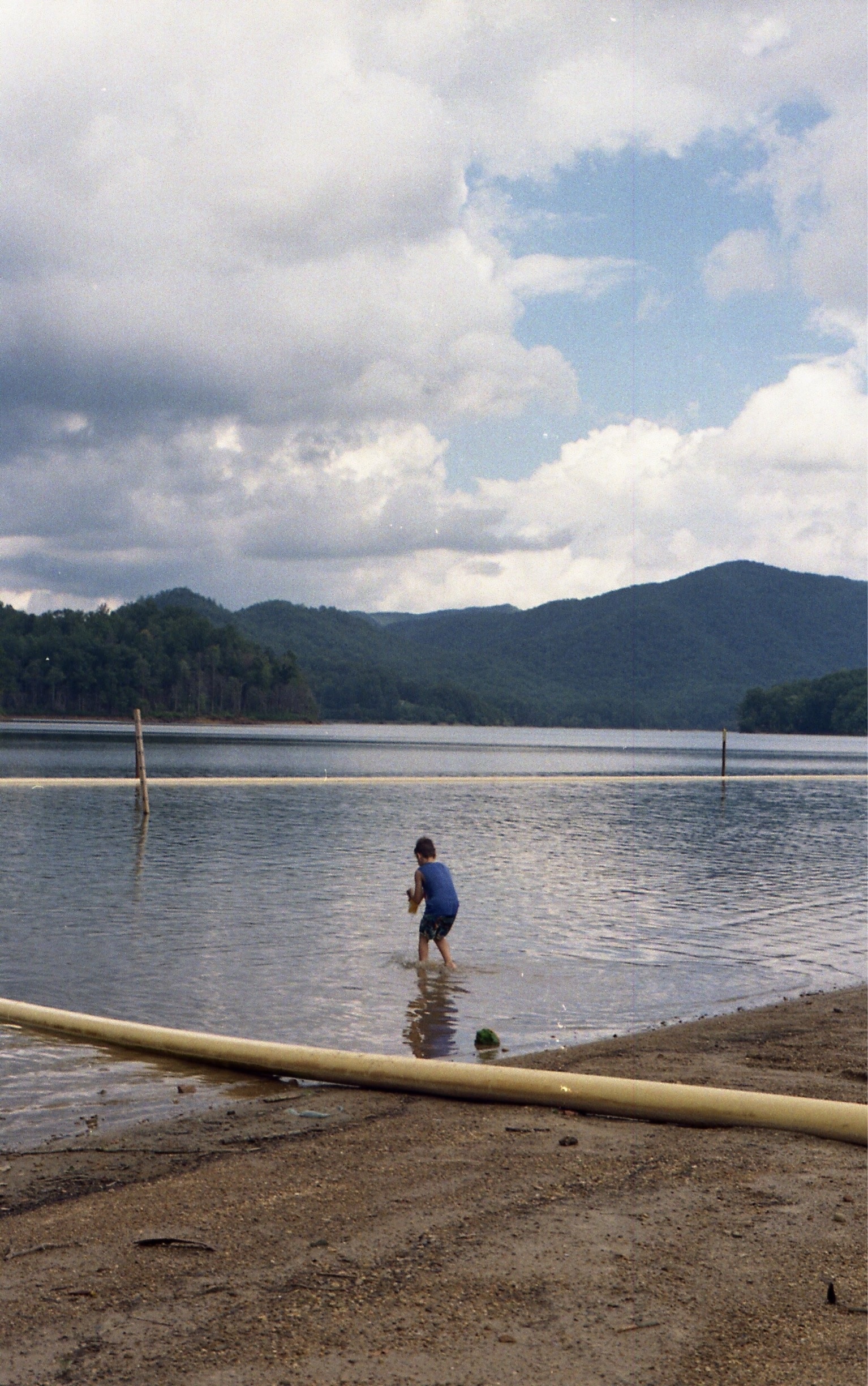 This image was created on a slightly warmer day at a popular swimming area right outside of the North Carolina border and barely inside of Tennessee at Watauga Lake. The child in the image is placed within the yellow pipe border that is placed on the beach for people who decide to go swimming to have a sense of boundary on depth of the water and something to rest on if they get tired while in the water. #appalachianechoes