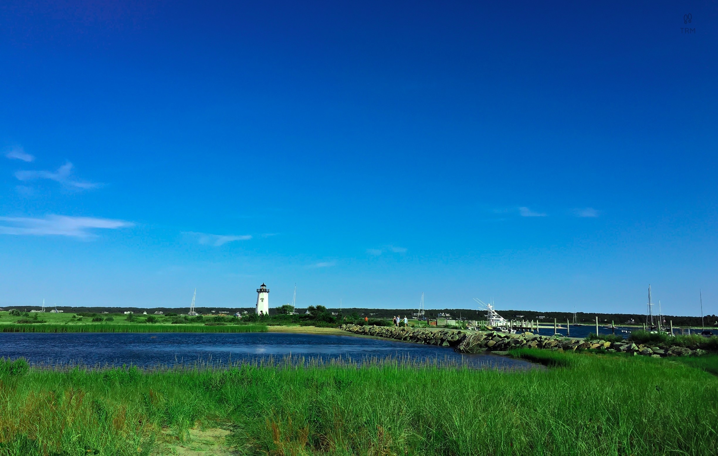 Sandy beaches, farmlands, fishing docks, harbor towns and tall lighthouses, Its Martha's Vineyard! It is around an hour of boat ride from Cape Cod to the Oak Bluffs. MV accessible only by boat or air. 
This picture was of course taken in summer :) Bright sunny day with blue sky and lush green. In the background is the famous east chop lighthouse. The best of my memories of MV are from East Chop.   We rented a bright Red scooter near the Oak Bluffs harbor after getting off from ferry, kicked off our slippers, rode to the sunset ;) I meant we drove to East Chop:)

Must Do : Get that pretty but awfully slow red scooter, drive to the light house, live the dream :)