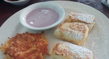 Cheese Blintzes - Grilled crepes with cottage and ricotta cheeses, flavored with orange zest and served with homemade blueberry sour cream sauce and a side of cheesy potato casserole from the Broken Egg in Sarasota.
