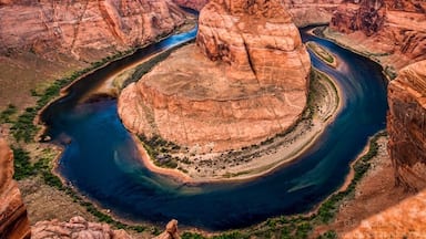 Located within a few hours drive from Las Vegas is this horseshoe shaped meander of the Colorado River. After a bit of a hike, we got to see the horseshoe bend. What an astounding beauty it was!

Also extremely nerve-wracking because it is a merciless 1000 feet drop from the canyon cliffs, and there are no rails at the edge of the cliffs. Being acrophobic made it worse! But it is an experience of a lifetime and I’m glad I mustered all of my courage (I have very little of it), prayed all the Gods in the world (although I believe there is only God) and peeked at the formation of the horseshoe bend among the deep gorges.

To get an elaborate view of the horseshoe bend, I lay down on my stomach and literally crawled on the canyon to reach the edges. The only thing I hoped is, the cliffs were strong enough to hold my weight. And here I was, literally at the edge of a 1000 feet high cliff with my palms sweating (literally!).