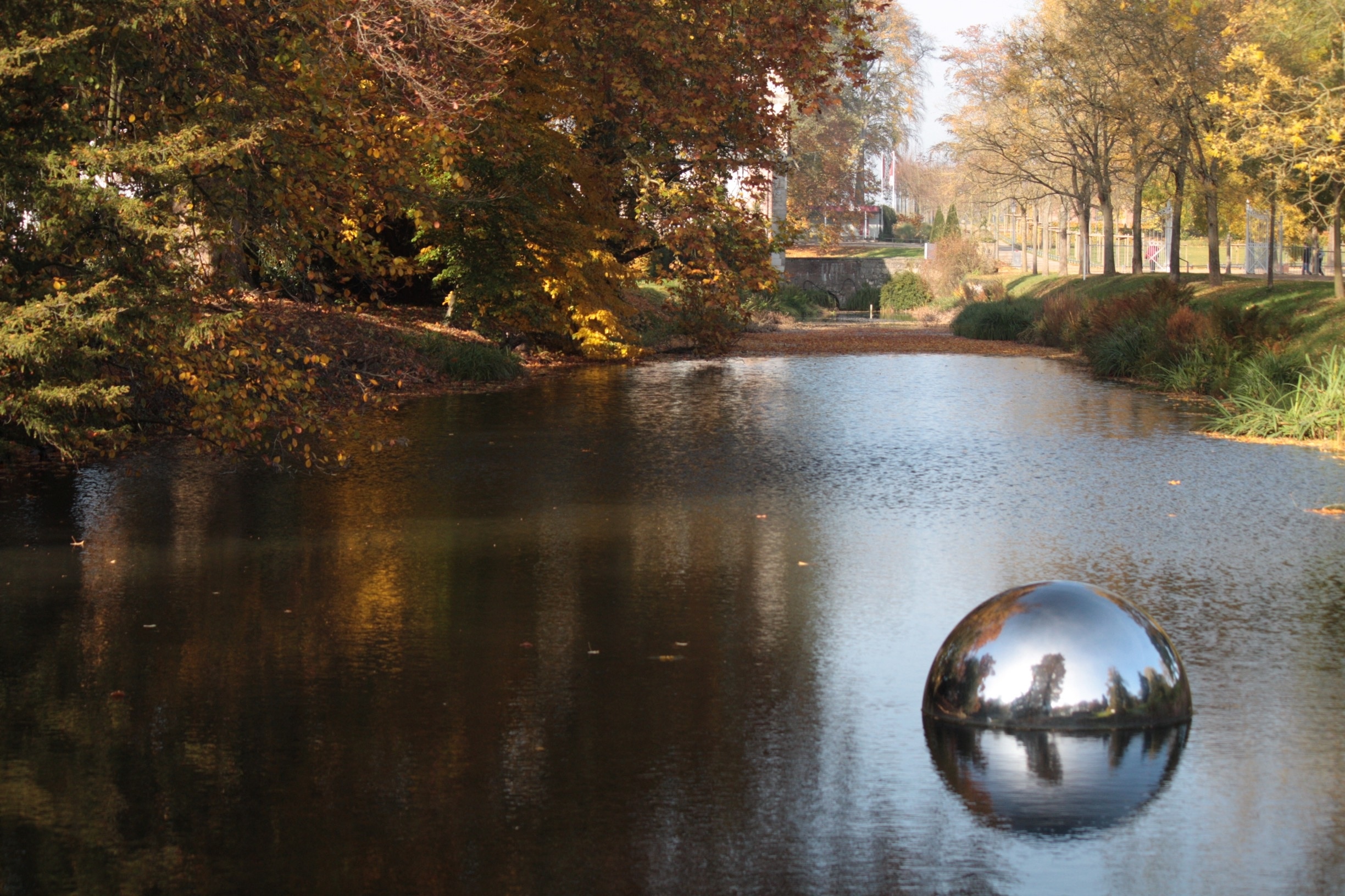 The large steel balls were placed in the water, which produces an interesting reflection of the surrounding trees.