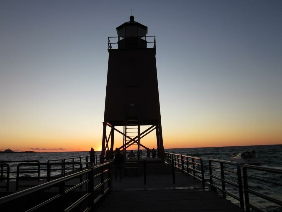 Every sunset is beautiful and magical in Upper Michigan. Charlevoix is a wonderful place to watch a sunset by the lighthouse on the beach overlooking Lake Michigan.