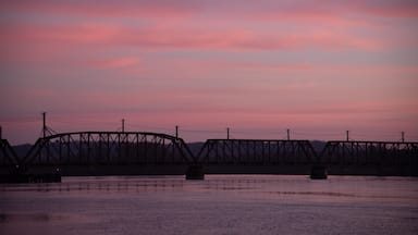 A railroad bridge crossing the Mississippi River at sunrise.