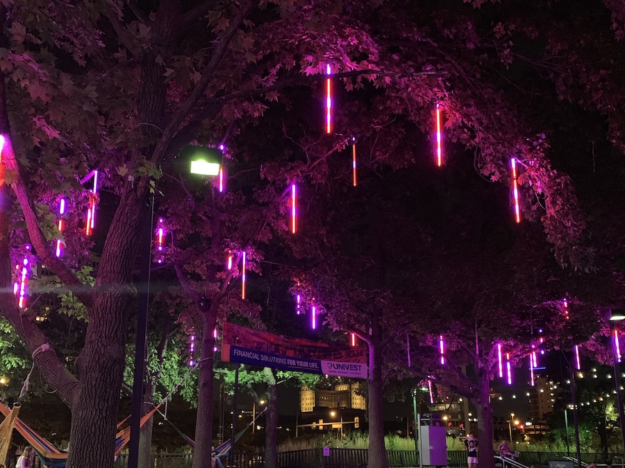 Night view of Spruce Street Harbor Park with colorful lights and hammocks in Philadelphia.