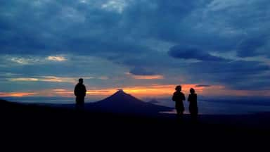 It's 5am and our Quetzaltrekkers guide wakes everybody up for breakfast and a sunrise. We're camping on Volcán El Hoyo and right next to a sinkhole as well. Behind us, cows and goats are grazing the grass. While in front, the blazing colours of the sub begin to appear, beginning this perfect and magical day. 