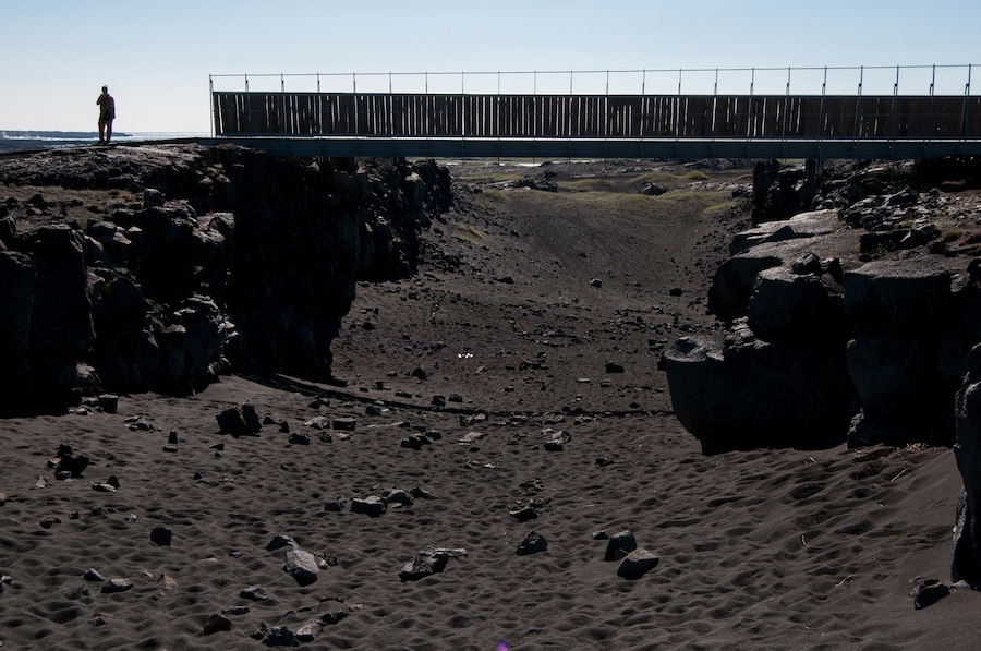 'Completed: 2002
Trivia: Reykjanes peninsula lies on one of the world's major plate boundaries, the Mid-Atlantic Ridge. With the Eurasian and North American tectonic plates continuously drifting apart, linear fractures, known as fissures, form. The Bridge between the two continents is a small footbridge over such a major fissure. Consequently, you can have one foot on European soil and the other on North American soil at the same time.'