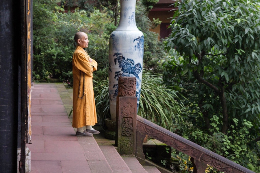 The Wannian (Ten Thousand Years) temple on Emei Shan (Beautiful Mei Mountain) is a place of serene atmosphere. The quiet is impressive, the architecture is very nice and the atmosphere is imposing.
As you enter the compound the first thing you see is a walled pond with fish, turtles, stones and money. Believers throw in paper money and coins, and monks take it out with a net. Inside the main pavilion is a statue of a golden Buddha on a white marble elephant. In front of this statue people bow, kneel and pray. In the back believers gently stoke the elephant's legs for reasons I didn't manage to figure out.