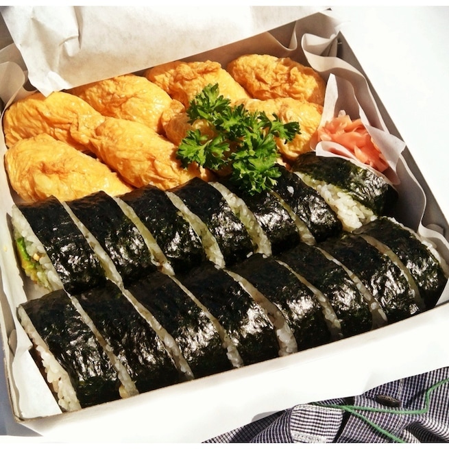 Freshly made inari and nori sushi bento unwrapped in the car