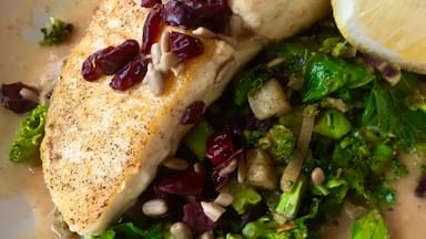 Braised Halibut rests atop of a bed of colorful vegetable crunch blend surrounded with a roasted garlic broth. Finished with cranberries and sunflowers seeds. #GoodEats #eatlocal