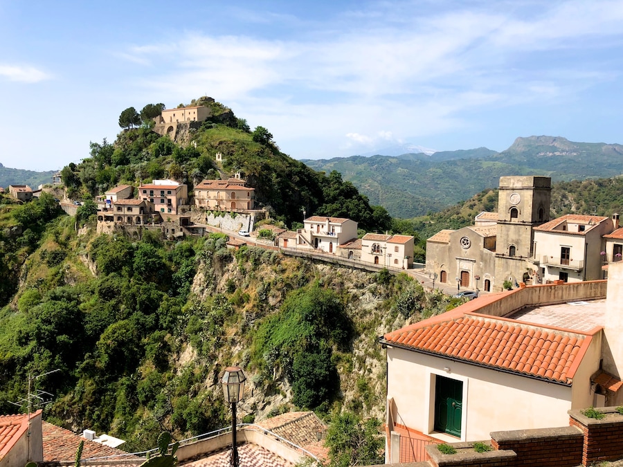 Savoca, one of the most beautiful villages in Italy, whose name is derived from the plant of the elder (savucu in Sicilian dialect), a shrub that still grows wild in the cracks between houses and which is represented in the medieval coat of arms of the village.
This small town set in the rock of a hill of dual tip, experienced the interest of kings, popes and Archimandrite prelates, in a succession of periods of serious crisis and prosperity. The basalt blocks lying on roads leading between separate small houses, freshly restored with Sicilian tiles on the roofs and windows framed in stone, then following streets in the rock here you’ll find extremely fragmented ruins and old cisterns.