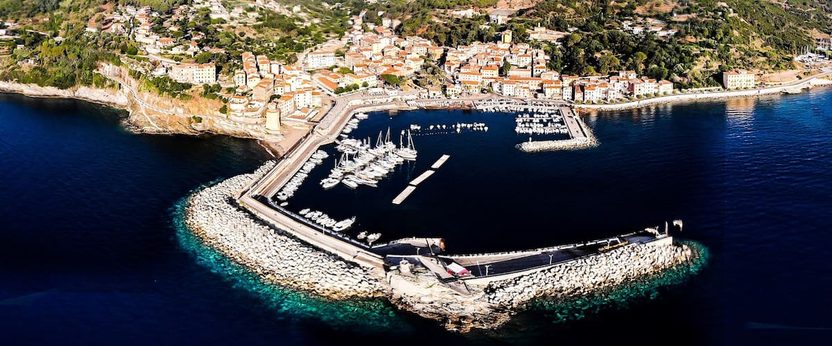 The town of Rio Marina is located on the eastern side of the Elba island, nestled gently in a small inlet surrounded by hills. In this area of the island, the coast that stretches from Rio Marina to Cavo is called the "Shining coast,” or “Costa che brilla” in  Italian. This nickname was given to honor the almost dreamlike glint that comes from the black mining dust