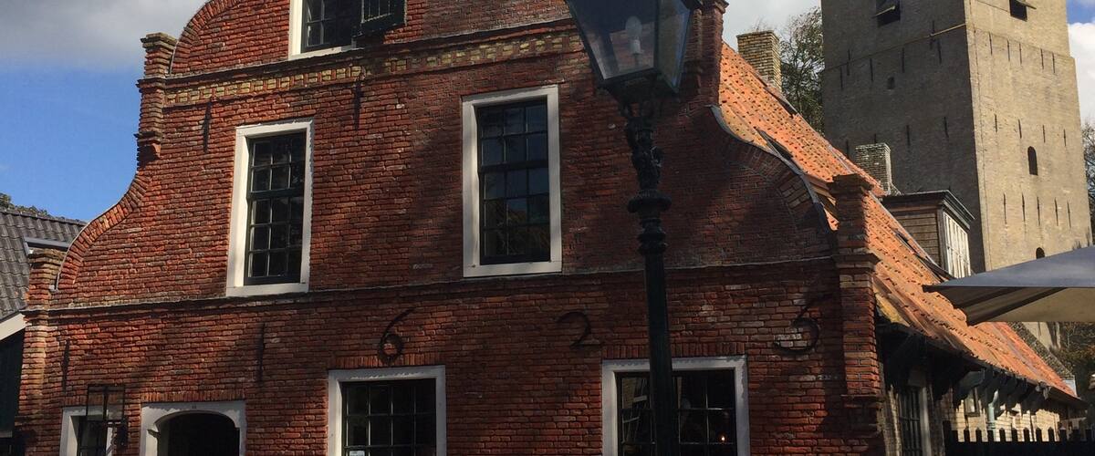 Characteristic Commandeur house on Ameland (Nes). In the background the village tower of Nes, Valerius (Watse) Frans van Cammingha and Rixt van Donia, lord and lady of Ameland instructed to build this tower in 1664. It served as a beacon for ships at sea.