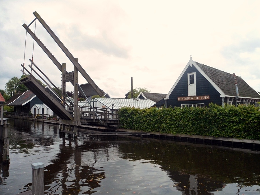 Walking through the bridge on a calm lake to the Historic Garden