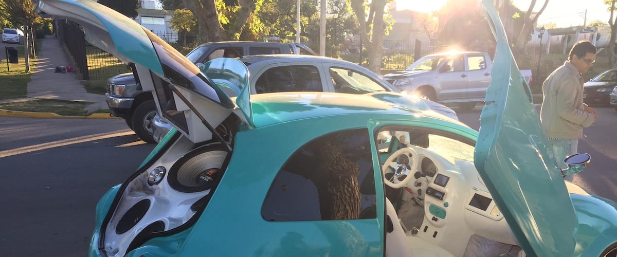 Los hombres estacionan sus autos en la costanera, con la música en alto