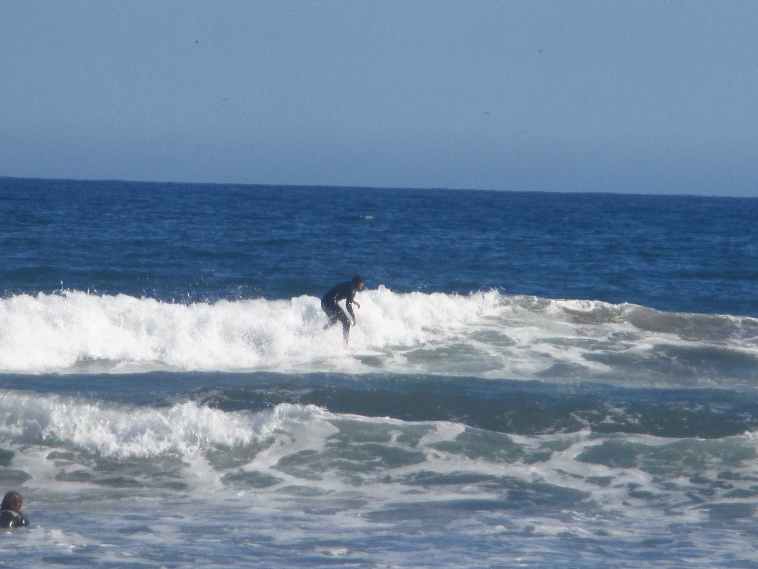 Surfers riding the waves in front of the beach in La Serena, Chile