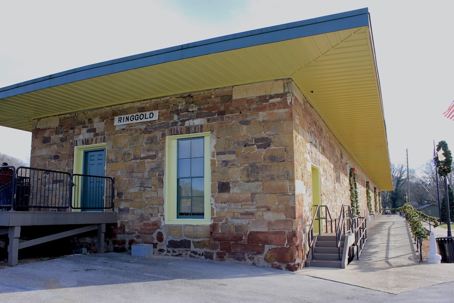 Constructed in 1849, the Western & Atlantic depot at Ringgold is one of the state's oldest rail stations. In 1862 Andrews' Raiders came through town in the locomotive General followed closely by their pursuers in the Texas. Andrews' unsuccessful attempt to disrupt Confederate rail operations came to an end two miles to the north of here.
After sustaining damage from Union artillery during the November 27, 1863 Battle of Ringgold, the 14-inch dark sandstone walls of the building were repaired with light-colored limestone blocks, giving the depot a distinct two-toned appearance.