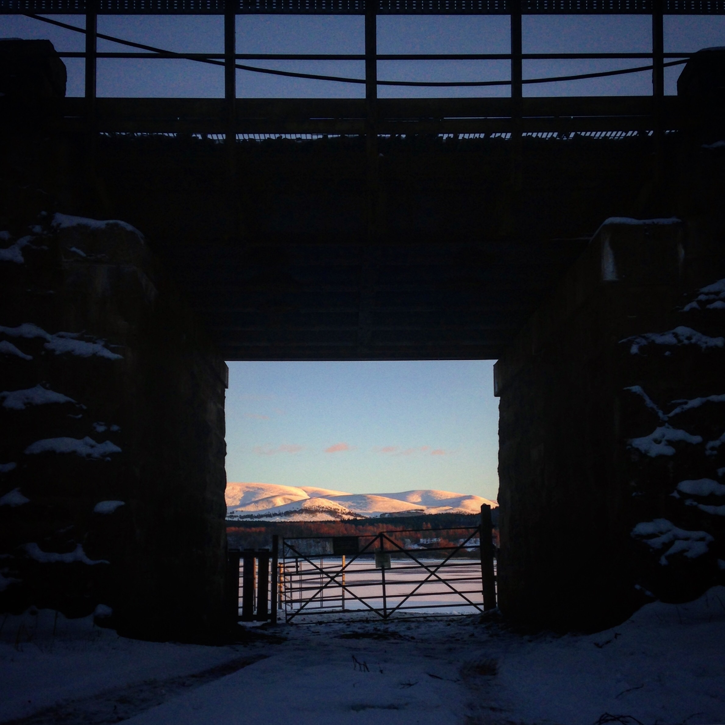📍Loch Insh, Kincraig.

A view of the Cairngorm Mountains over a frozen Loch Insh and through the underpass of the railway line.
