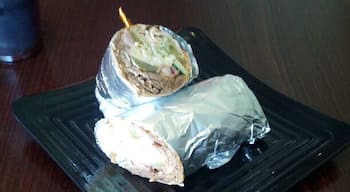 A wrap with gyro meat, lettuce, onions, cucumbers, pickles, feta cheese and kalamata olives from Mezze Middle'Terranean