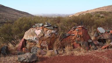 Driving from Karijini NP to Tom Price you'll pass the rest in peace lookout. Scattered over the parking are stones to remember people. The place also has a great view