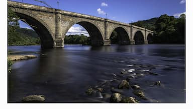 a photo of the historic bridge at Dunkeld with the river meandering along through the town