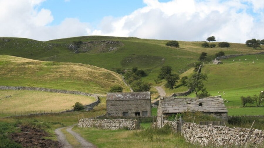 Photo "Lane and stone barns above Carperby. Once an important route out of Carperby towards quarries, a limekiln, supplies of turf, and Castle Bolton. Now much used by walkers heading for the hills." by Gordon Hatton (Creative Commons Attribution-Share Alike 2.0) / Cropped from original