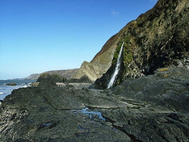 Waterfall on Tresaith Beach Afon Saith cascading down cliffs onto Beach at Tresaith