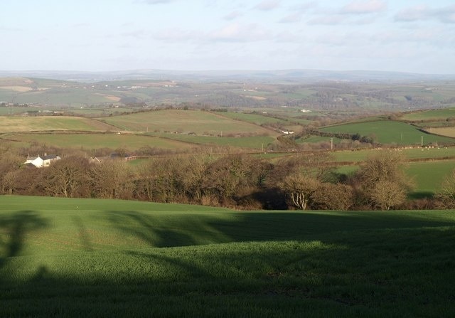 Northeast from Luppincott The farm on the left is Nethercott. One of the small streams that forms the natural bowl of this square follows the nearest line of trees. Beyond, the land rolls away towards the Taw valley, with Exmoor in the distance.