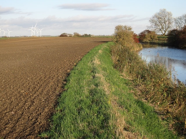 Footpath by the Nene The field has been ploughed and harrowed up close to the river, leaving a narrow and pitted footpath. Stagsholt windfarm in the background.