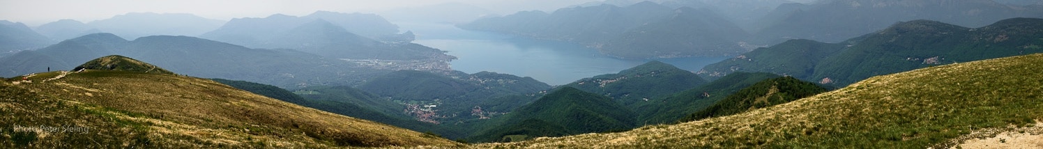 Blick vom Gipfel des Monte Lema in Richtung Lago Maggiore, Luino, Brissago. Rechter Hand unter den Wolken ist die Alpenkette mit dem Monte Rosa zu erkennen. Das Panorama wurde aus neun einzelnen Hochkant Aufnahmen erstellt. View from the top of Monte Lema to the Lago Maggiore with the town Luino and the Brissago Islands. The Alps, with the Monte Rosa, can be found In the upper right hand corner below the clouds. The panorama image was built from nine single pictures. Foto Peter Sieling twitter: @Bluespete