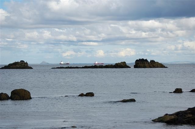 Rocks These rocks are known as East Vows. The ships in the picture are in a holding area awaiting berths in ports further up the estuary, Leith, Rosyth or Grangemouth.