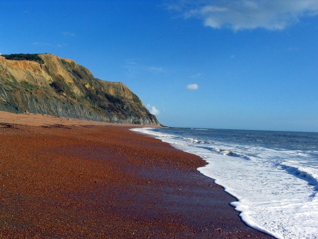 Ridge Cliff and East Ebb from the water's edge. A lovely view East from Seatown Beach at low water, with Ridge Cliff and East Ebb rocks central, and Portland just discernible on the horizon.