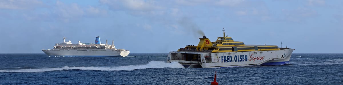Photo "Ships leaving the port of Santa Cruz de La Palma (Canary Islands). Left: cruise ship MS Thomson Spirit. Right: fast ferry HSC Benchijigua Express." by MJJR (Creative Commons Attribution 3.0) / Cropped from original