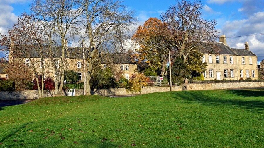 Photo "Green at west end of Whalton Village" by Andrew Curtis (Creative Commons Attribution-Share Alike 2.0) / Cropped from original