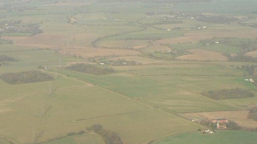 Photo "A square from the air Looking north-ish from a plane, at TL4314. The map square below also includes a 500m border, meaning that you can see Gilston church in the next square south, as you can in the picture. (Below the copyright notice, you can also see the tongue of woodland that is at the bottom of the picture.) Beyond that, you can see where the pylons march right through this square, maintaining a dead-straight line. Clearly marked are the two woods, the pylons passing over the right-hand corner of the first and the left-hand corner of the other. Looking at the 1:25,000 map (using the Get-a-Map link on this page), you will be able to recognise lots of other features  for example, the little track in the foreground that just fizzles out in the middle of a field (in the next square south)." by Chris Downer (Creative Commons Attribution-Share Alike 2.0) / Cropped from original