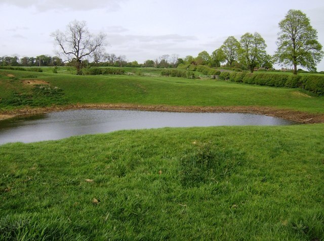 The line of the footpath between the Bringtons. This pond, recently constructed, is directly on the line of the footpath between Great Brington (ahead) and Little Brington (behind). It is a simple diversion round to the right, but is completely unseen from the start of the path at the gate (middle right). See 446946