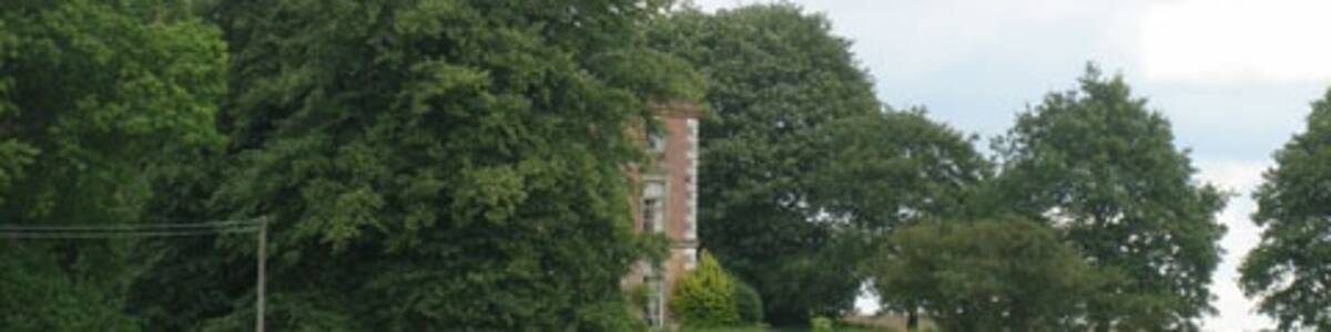 Photo "Glimpse of the south facade of Thurning Hall A well-placed tree (beech? lime?) shields the Hall from public gaze - but not, presumably in winter." by Zorba the Geek (Creative Commons Attribution-Share Alike 2.0) / Cropped from original