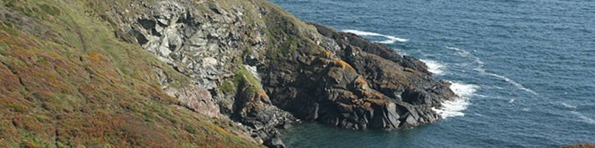 Photo "Landewednack: Enys Head With Black Head in the distance" by Martin Bodman (Creative Commons Attribution-Share Alike 2.0) / Cropped from original