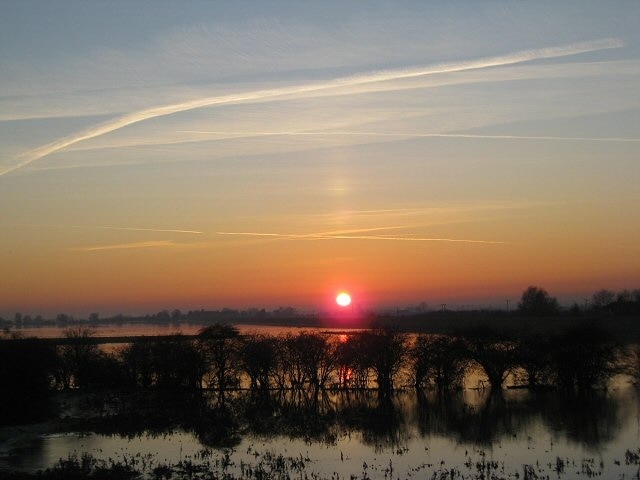 Setting sun over the Hundred Foot Washes The partially submerged hedgerow is the only sign that in summer this land is used for grazing. In the winter, as now, the area is allowed to flood.