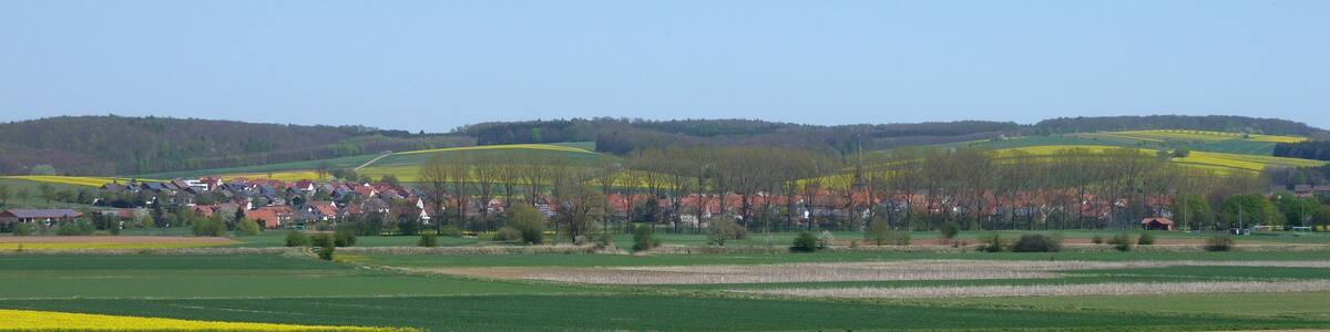 Photo "Blick von Westen vom Hang des Roten Berges auf Obernfeld, Landkreis Göttingen, Südniedersachsen. Im Hintergrund Teile der Hellberge" by Dehio (Creative Commons Attribution-Share Alike 3.0) / Cropped from original