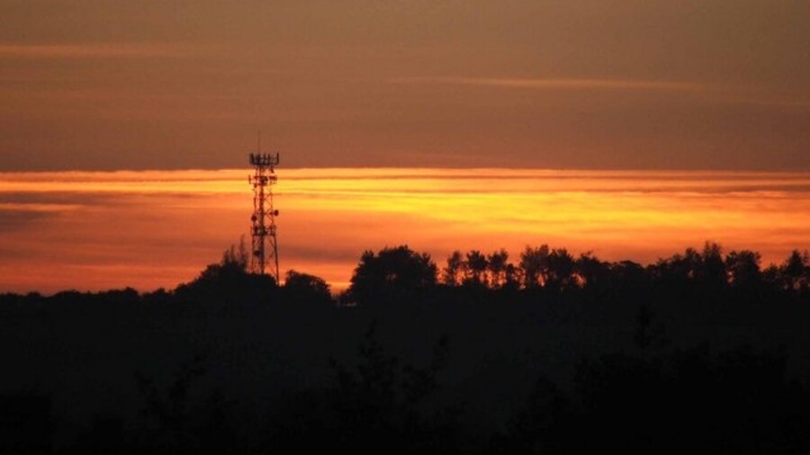 Photo "Dawn on Red Hill Communications mast at Red Hill on the A5." by Mike White (Creative Commons Attribution-Share Alike 2.0) / Cropped from original