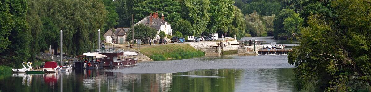 Photo "Chisseaux (Indre-et-Loire) Le Port Olivier et l'écluse. Au XIXe siècle, le Cher est canalisé depuis Noyers-sur-Cher jusqu'à Saint-Avertin. La commune, est pourvue en 1830-1840 d’un barrage à aiguilles sur le Cher, d'une écluse rive droite. L'écluse mesure 35 m de long sur 5,15 m de large. Le barrage est composés d'aiguilles en bois de 2,50 m de haut sur 7 cm de large et d'un déversoir sur la gauche. Le 7 juin 2010 le déversoir de Chisseaux tue 2 navigateurs qui tentaient de franchir le barrage. Le dangereux phénomène de rappel* est trop souvent méconnu. Le rappel est une : "Perturbation dangereuse dans l’écoulement de l’eau pouvant survenir en bas d’une chute d’eau. Cette perturbation entraîne une émulsion de l’eau, un mouvement de surface qui ramène l’eau vers la chute, un affouillement qui creuse une excavation au pied de la chute. Les barrages artificiels ou des chutes naturelles peuvent avoir un rappel à leur pied ce qui interdit totalement leur franchissement." (rivieres.info/lex/lexique.htm) (rivieres.info/secu/84-barrages.htm)" by Daniel Jolivet (Creative Commons Attribution 2.0) / Cropped from original